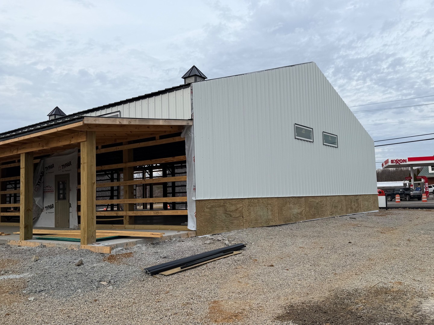 Exterior view of Thompson's Station Hardware construction in Franklin, TN, showing metal siding installation in progress with windows installed on the side of the building.